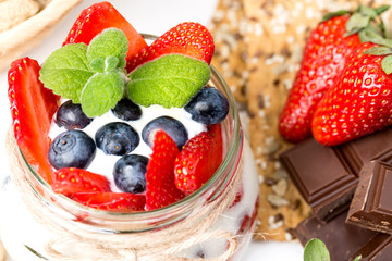 Strawberries, blueberry, nuts, chocolate and mint as the delicious healthy dessert.