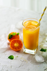 Orange juice with ice and tangerines on white background. Free space for your text. Copyspace. Cold beverage for hot summer day.