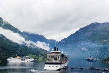 GEIRANGER, NORWAY - a Panoramic view of Geirangerfjord in Norway which features 3 cruise ships.