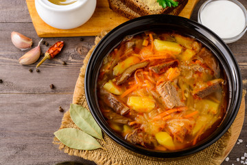 Shchi - traditional russian cabbage soup on wooden table.