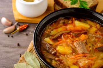 Shchi - traditional russian cabbage soup on wooden table.