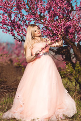 Obraz na płótnie Canvas Pregnant happy girl in spring pink garden