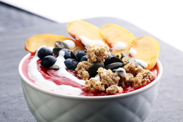 breakfast smoothie bowl with blueberries, peach and granola
