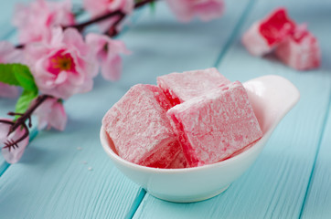 Rose flavored rahat lokum Turkish delight on wooden background. Selective focus. Ramadan food