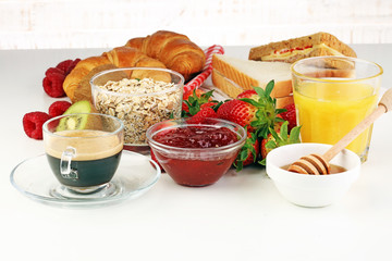 breakfast on table with sandwiches, croissants, coffe and juice