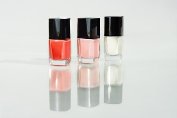 Three varnishes for nails of different color with reflection