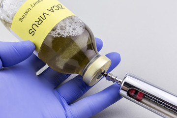 Scientist with blue latex gloves fills pesters of remedy of the virus ZIKA in a laboratory during...