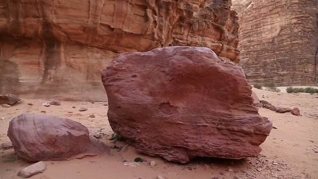Red stones in Wadi Rum desert, Hashemite Kingdom of Jordan. Amazing scenery of Wadi Rum desert in Jordan, also known as The Valley of Moon. Wadi is a term traditionally referring to a valley