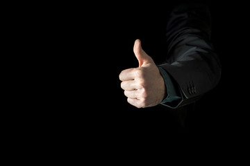 Hand of a businessman wearing black business suit showing thumb up
