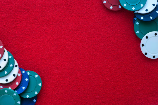 Red felt table with poker chips over it and copy space. Casino, gambling, poker and roulette theme