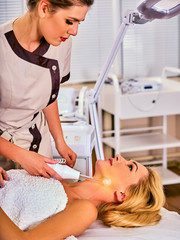 Obraz na płótnie Canvas Face beauty treatment therapy for woman getting facial darsonval procedure . High frequency skin care device at cosmetology medical center.