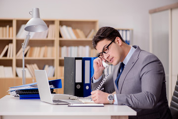 Businessman speaking on phone in office
