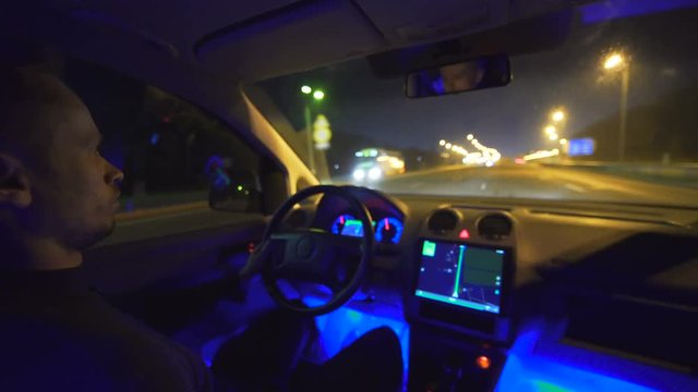 The serious man drive a car on the road. evening night time. inside view, real time capture