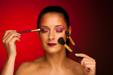 beauty portrait of a woman with makeup brushes