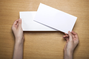 Obraz premium woman hand hold a letter with envelope on the wood table.