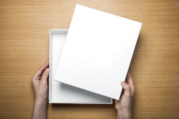 Fototapeta premium woman hand hold a paper on the wood table(background)