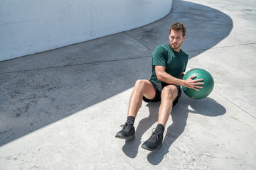 Medicine ball exercise russian twist man. Abs workout - fitness athlete working out doing exercises...