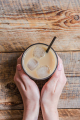 iced coffee in hands for cold summer drink on white background top view