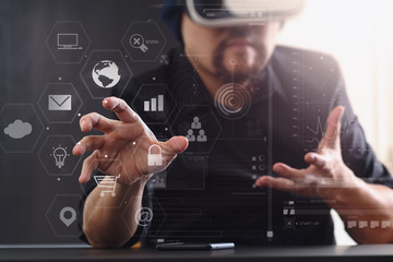 businessman wearing virtual reality goggles in modern office with mobile phone using with VR headset with screen icon diagram