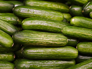 Fresh pickles stacked at a farmers' market