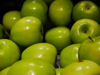 Closeup of many green juicy apple fruits in market
