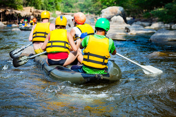 Young men and women are rafting on the river, extreme and fun sport at tourist attraction