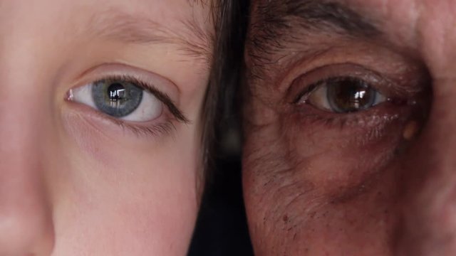 Eyes of grandfather and grandson opening, close up
