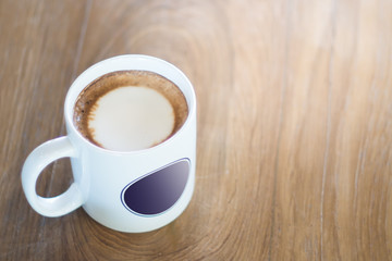 Hot coffee in the large white cup on the wooden table background
