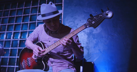 Guitarist at scene in bar - musician in hat plays guitar