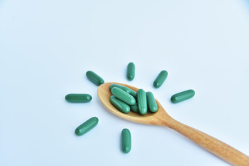 medicine and wooden spoon on white background.
