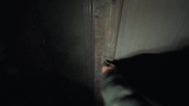 Point of view man with flashligh wandering in dark corridor inside scary abandoned building opens door post apocalyptic war scavenger stalker, lots of trash