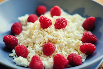 Diet curd with raspberry on a plate.
