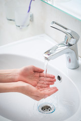 The boy is washing his hands