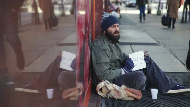 Desperate homeless asking charity in the street