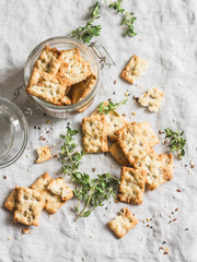 Salty sunflower seeds and thyme crackers on a light table, top view. Delicious snack