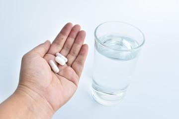 hand holding medicine and glass water.