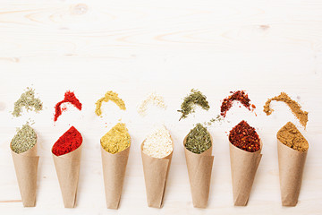 Oriental colorful powder condiments pattern as decorative border on white wooden board with copy space.