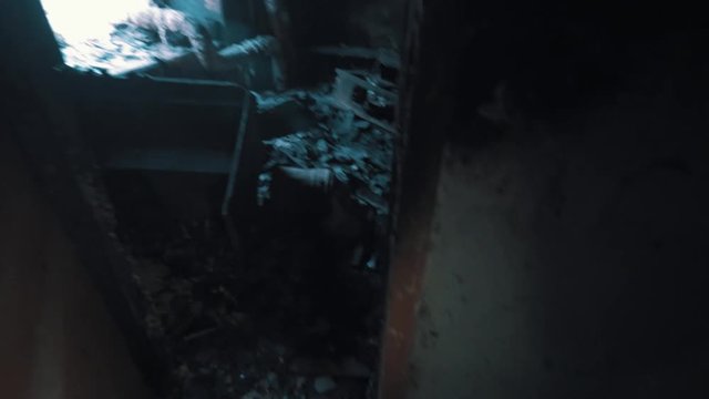 Point of view man hand opens door leading into into burned out room inside abandoned building, post apocalyptic war scavenger stalker, lots of trash