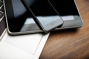 keyboard with phone and tablet pc on wooden desk