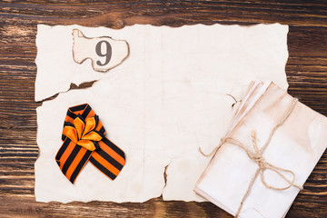 Tied George Tape lies on a table on an old paper, postcard on a holiday