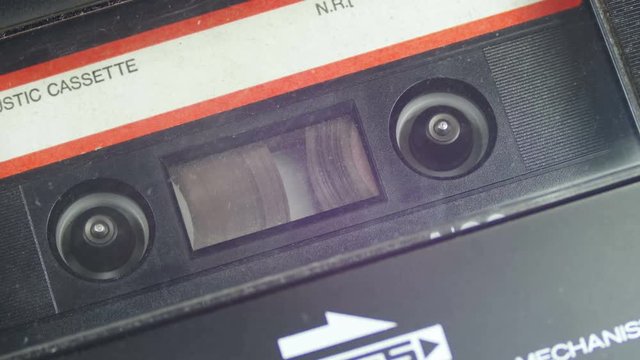 Insert an Audio Cassette into a Tape Recorder and Rewind. Vintage tape recorder Rewind the tape inserted therein. Close-Up. Tape with blank label in use sound recording in cassette player.