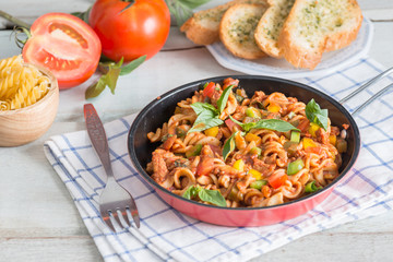 Pasta with tomato sauce in pan.