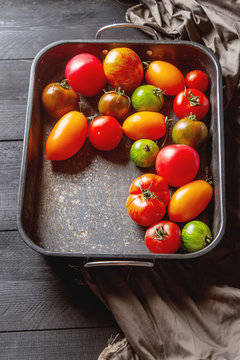 Colorful ripe tomatoes. Delicious vegetarian food. Dark background.