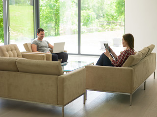 couple relaxing at  home with tablet and laptop computers