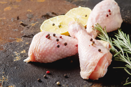 Chicken legs with rosemary, pepper and lemon. Dark background. Lunch on the grill. Space for text.
