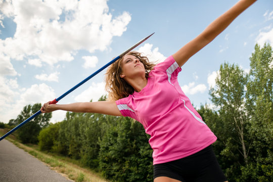 Young Woman Throwing A Javelin In Nature