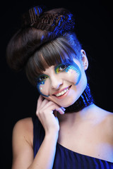 Young  woman with bright make up over blue background