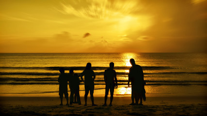 a family enjoying a beautiful view of the sunrise side of the beach
