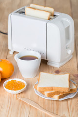 Sandwiches and jam, coffee with toaster on table.
