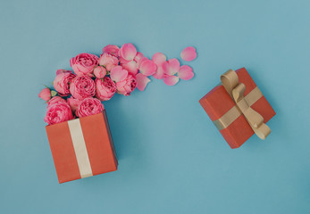 Open red gift box full of pink roses